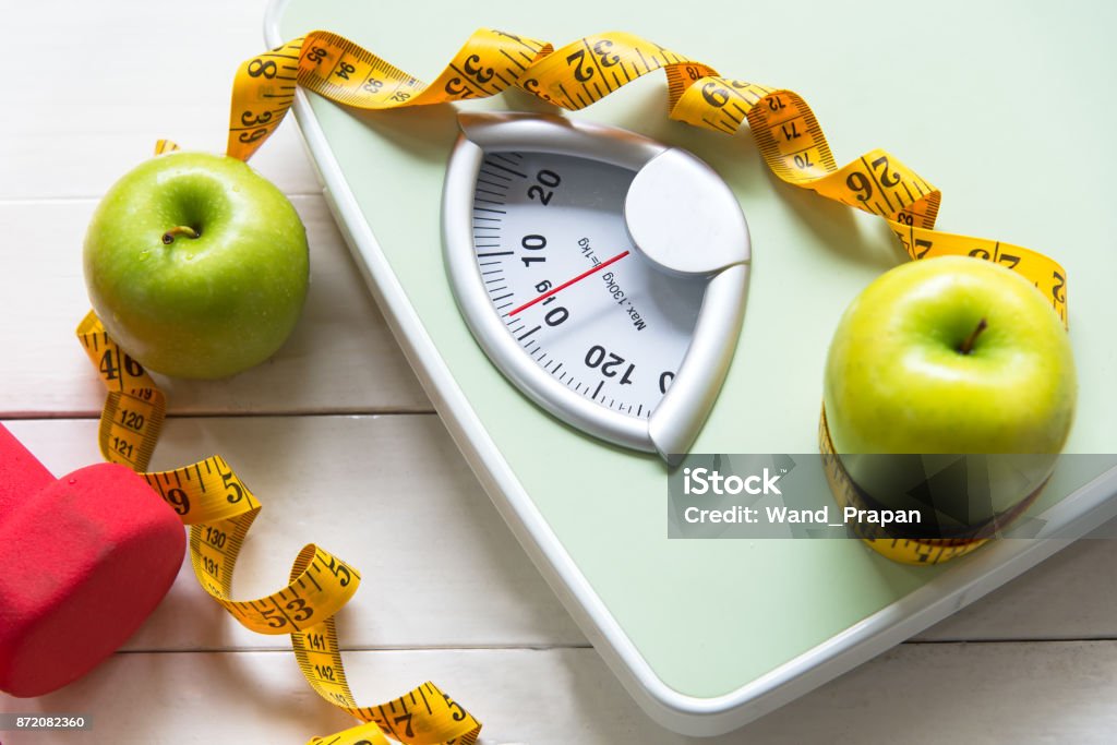 Pomme verte avec le pèse-personne et ruban à mesurer pour la minceur de la saine alimentation. Alimentation et santé Concept - Photo de Régime amaigrissant libre de droits