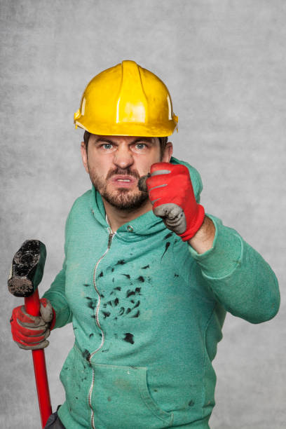 istock a worker with a big hammer, clenched his fist 872088988