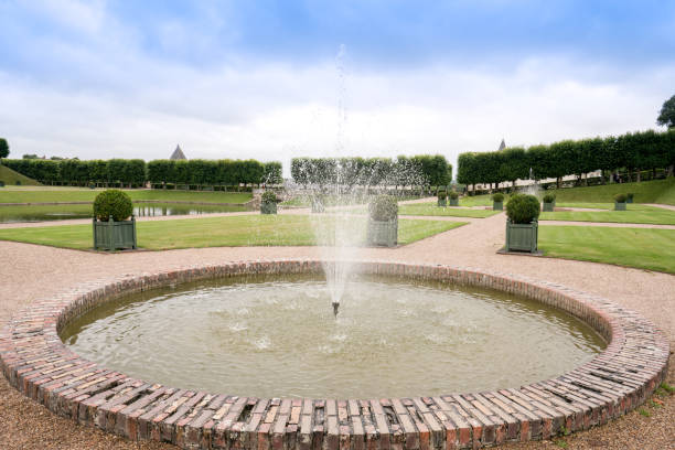 istock Small Fountain in green grass garden & blue sky 872089218