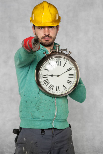 istock worker points to you, the clock in hand 872089592