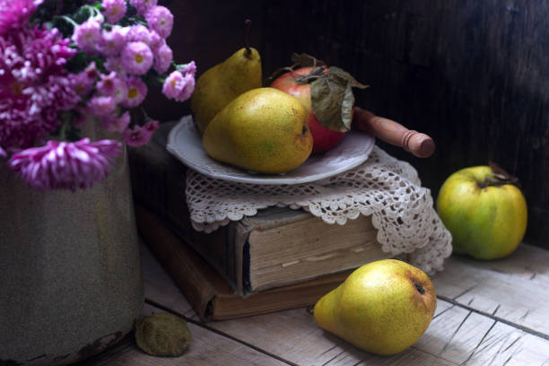 istock Autumn still life with pears, apple, chrysanthemums and books. Rustic style. 872092898