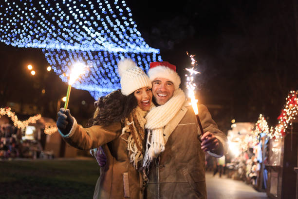 istock Young couple having fun with sparkling candles at night 872093472