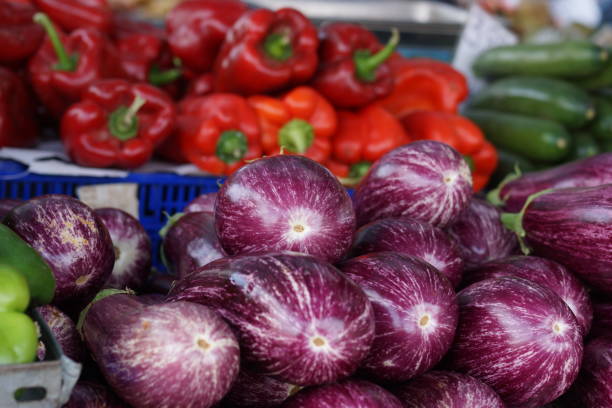 istock Eggplants and peppers on the vegetable counter on the market 872093504