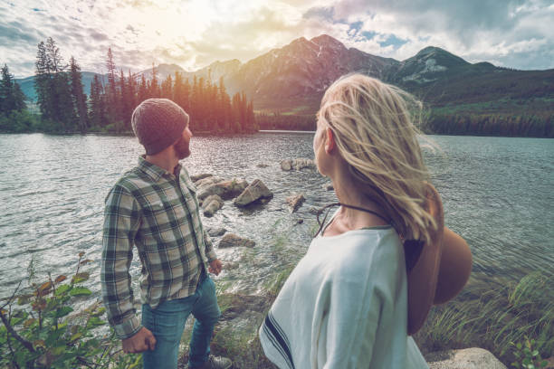 istock Young couple overlooking mountain lake, Canada 872096504