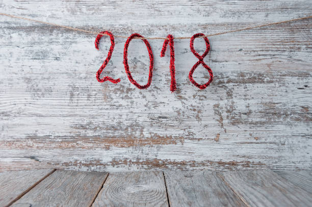 istock New Year 2018 background on a wooden surface with shiny numbers. 872115698