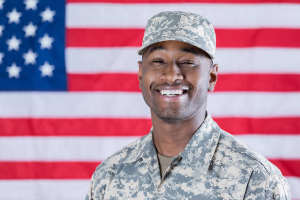 fier jeune homme militaire pose devant le drapeau américain - black and white military uniform headwear one person photos et images de collection