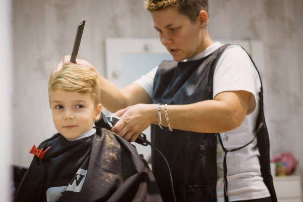 istock Small boy getting haircut at barber shop. 872131376