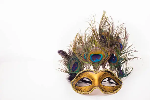 Venetian carnival mask with peacock feathers on white background