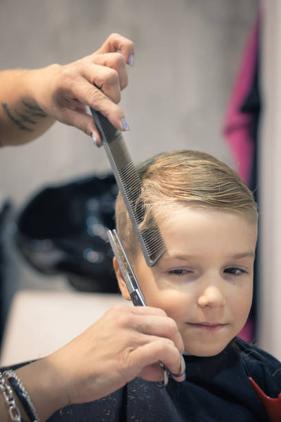 istock Cute boy getting a haircut at the salon. 872131962