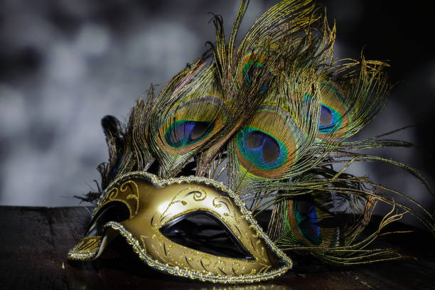 máscara veneziana de carnaval com penas de pavão em fundo escuro - mardi gras close up veneto italy - fotografias e filmes do acervo