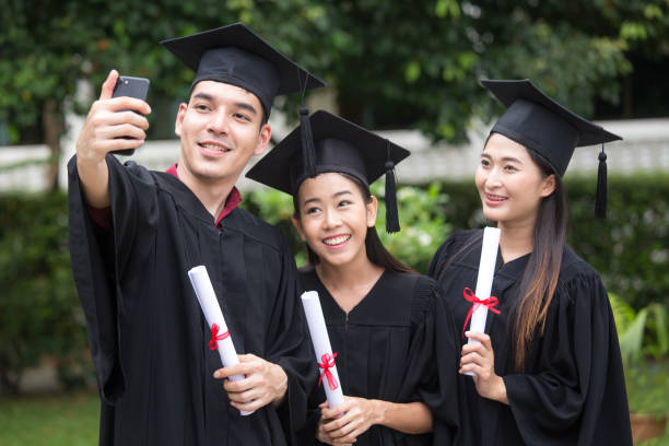 istock Young Asian Students using Smartphone for Selfie with Friend at University, Students  with Graduation Concept. 872143236