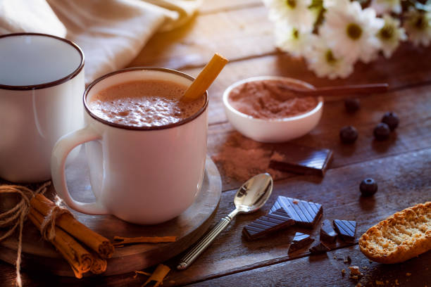 Two homemade hot chocolate mugs on rustic wooden table