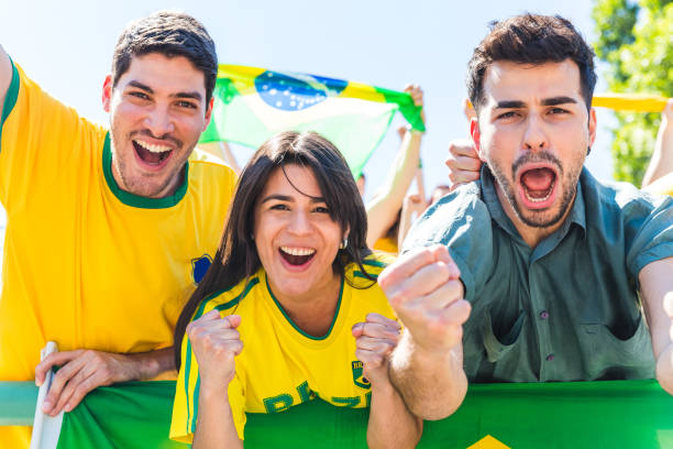 istock Brazilian supporters celebrating at stadium with flags 872147588