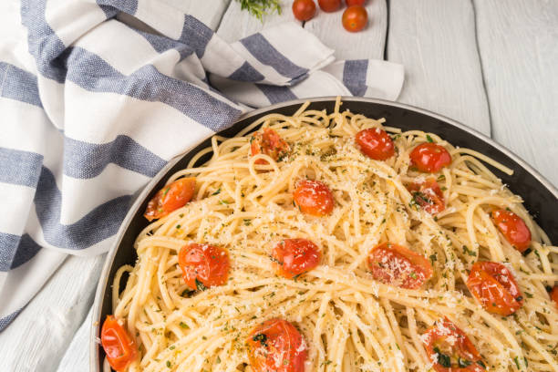istock Spaghetti pasta with tomatoes and parsley on wooden table 872163144