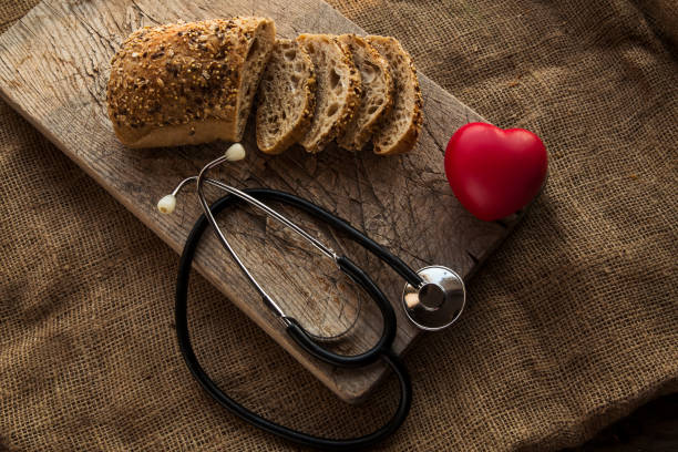 Sliced bread on a  cutting board with red heart shape figure.