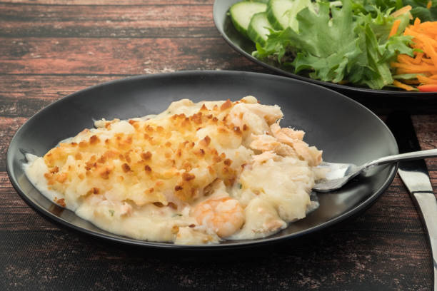 Fish pie Fish pie topped with potato mash and a side salad fish pie stock pictures, royalty-free photos & images