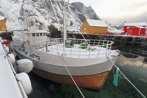 Old wooden fishing boat moored-snow covered harbor-Nusfjord fishing village. Flakstadoya-Lofoten-Norway.0496