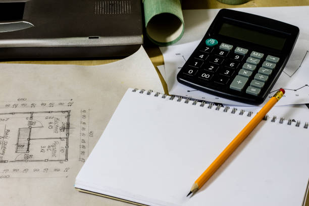 istock architect's table, laptop, calculator on the table. Plans, projects and notepad on the architect's table. 872181944