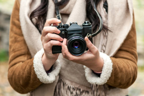 istock Young woman using old 
analog photo camera 872186890
