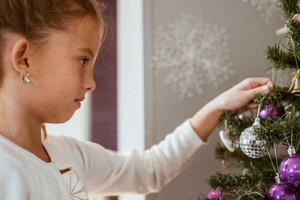 istock Cute girl decorating christmas tree 872188094