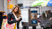 Young woman text messaging on the street