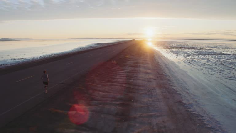 Aerial view of a young woman on a sunrise run at the Bonneville Salt Flats
