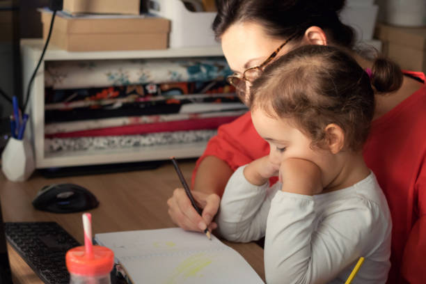 istock Daughter and mother coloring in note book at home. 872193108