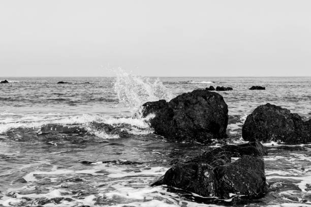 Waves breaking on rocks at the seashore in Pomos, Cyprus. Black and white photo