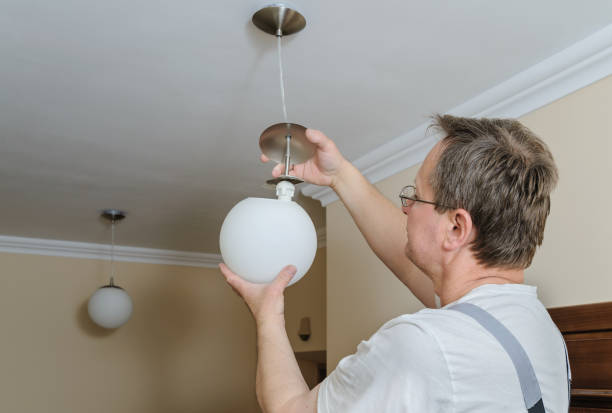 istock Electrician is instilling a ceiling lamp. 872207906