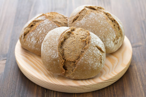 istock bread on wooden dish on brown background 872210250
