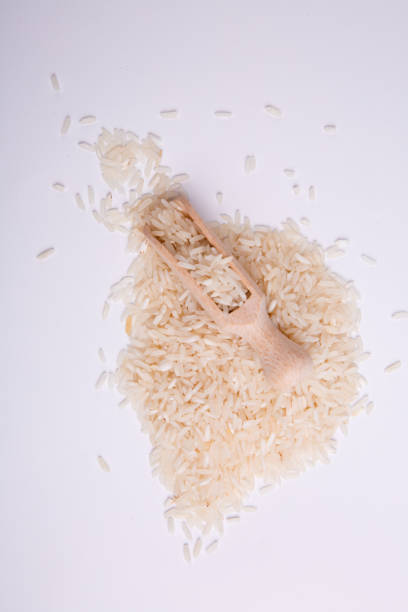 istock White rice in a wooden shovel on white background. Vertical image 872214226
