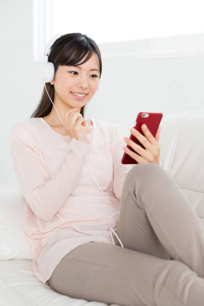 istock young asian woman relaxing on sofa 872218456
