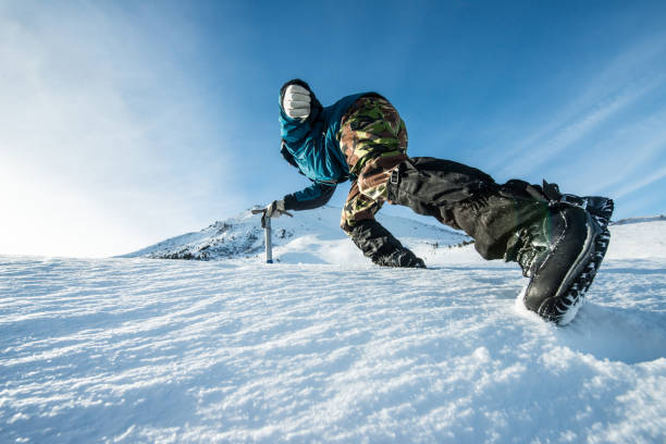 istock climber with an ice ax climb on the snowy mountain 872226174