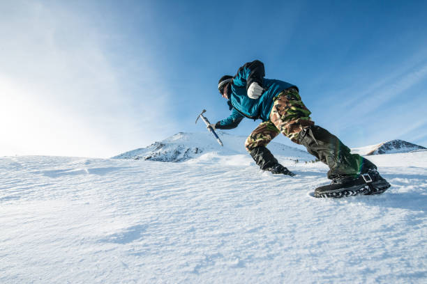 climber with an ice ax climb on the snowy mountain