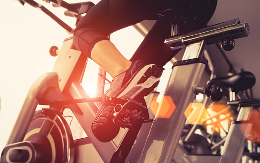 Ejercicio de entrenamiento de bicicleta cardio en el gimnasio de mujer tomando la pérdida de peso con la máquina aeróbica para delgado y firme sano en la mañana. photo