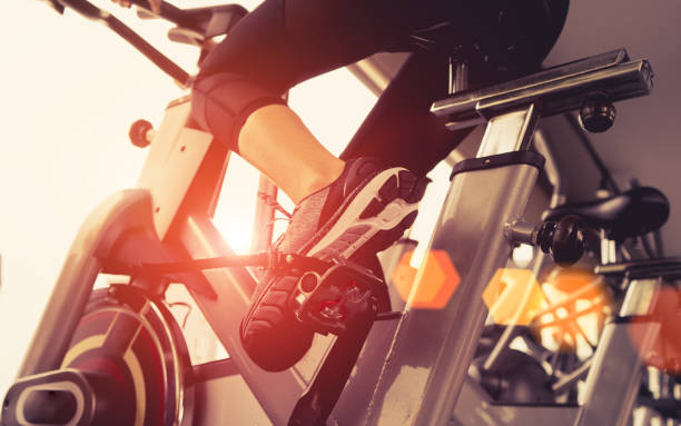 ejercicio de entrenamiento de bicicleta cardio en el gimnasio de mujer tomando la pérdida de peso con la máquina aeróbica para delgado y firme sano en la mañana. - bicicleta estática fotografías e imágenes de stock