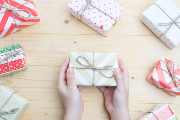istock kid holding christmas presents  on wood background 872231888