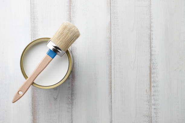 istock Paint brush and can on white wooden table 872231956