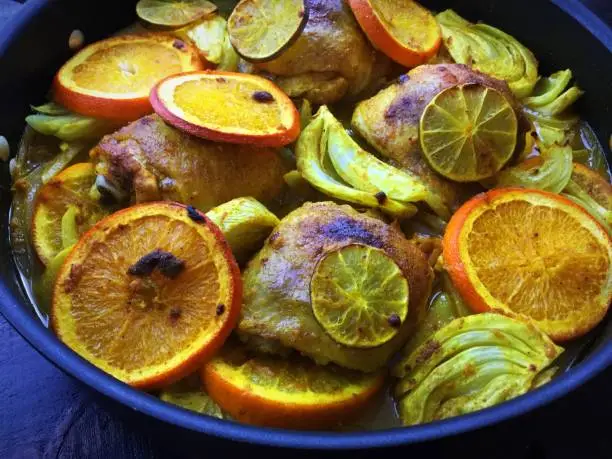 Chicken roasted with sliced oranges, lime, fennel and onions in a turmeric sauce