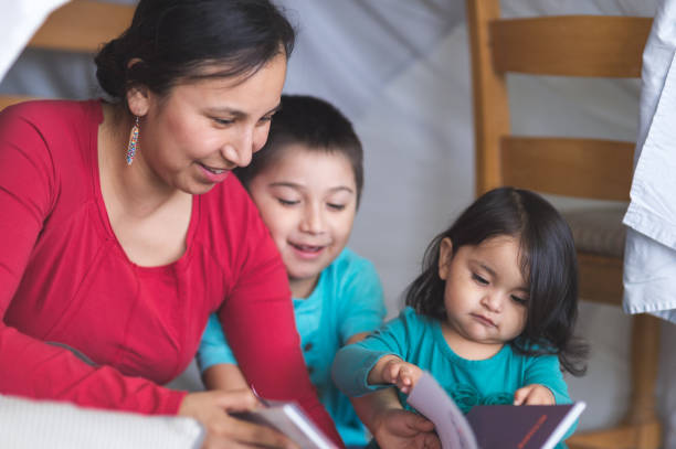 native american mom reads with her son under makeshift fort in living room - índia imagens e fotografias de stock