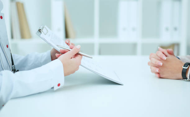 istock Female doctor holding application form while consulting patient. 872249324