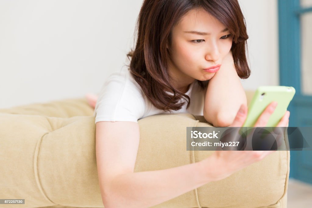 woman using smart phone, think, young attractive asian woman using smart phone, think, Smart Phone Stock Photo