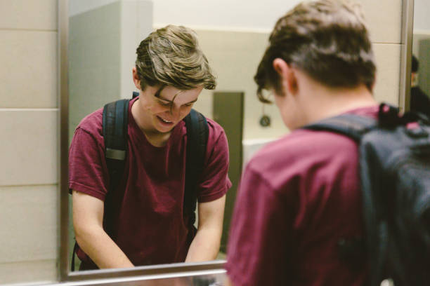 istock Young Man Happily Washing Hands in Public Restroom 872260992