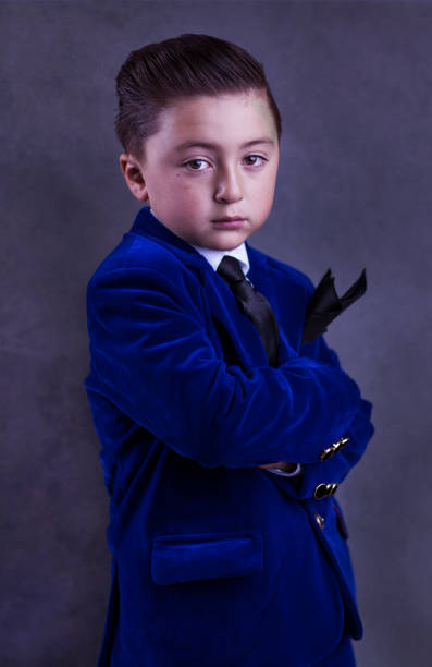 niño guapo con el pelo estilo llevando un traje de terciopelo azul elegante vestido con lazo negro y handkercheif - handkerchief necktie fashion tuxedo fotografías e imágenes de stock