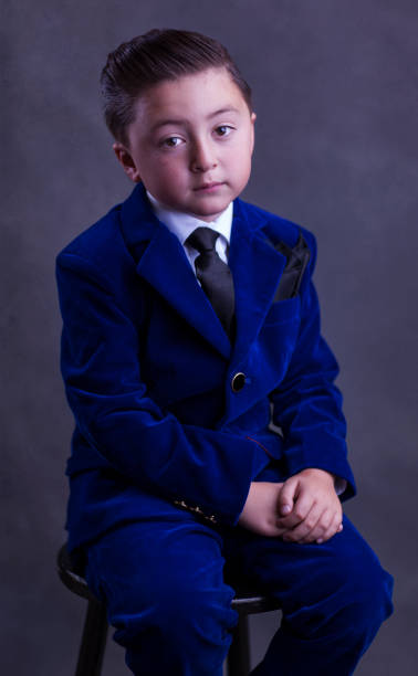 raza mixta guapo asiático caucásico niño con estilo pelo engrasado copete marrón lleva un traje de vestido de terciopelo azul elegante con corbata negra y pañuelo con los brazos cruzados - handkerchief necktie fashion tuxedo fotografías e imágenes de stock