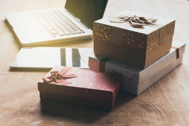 istock Laptop with tablet and gift boxes on wooden table. 872274396