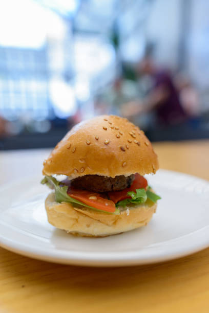 istock Small bit-sized hamburger served in white plate on wooden table 872277982