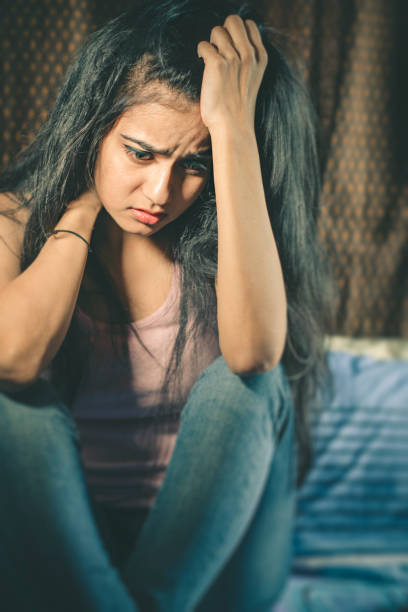 istock Unhappy young woman holding her head. 872278200