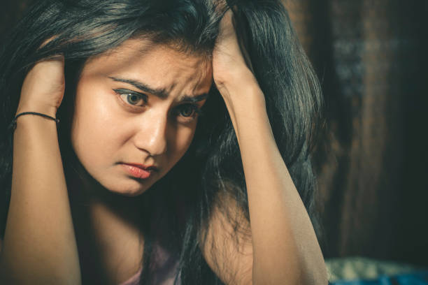 istock Unhappy young woman holding her head. 872278206