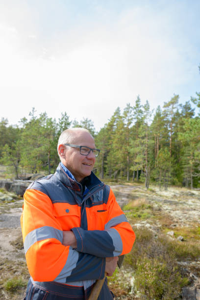 istock Mature handsome man working and felling trees in the forest 872281444